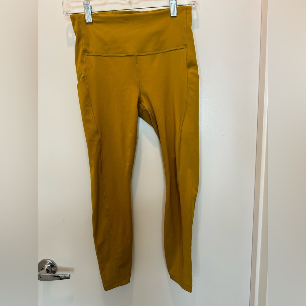 Athleta ultimate stash pocket 7/8 tight mustard. Size small